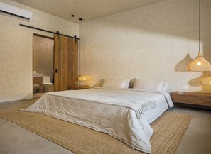 Une chambre moderne avec un grand lit, une armoire en bois, une table de chevet avec une lampe et un climatiseur fixé au mur.