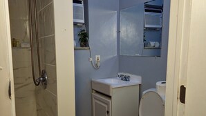 A bathroom with a shower, toilet, sink, and a mirror above the sink. - TheVacaVacationHomes (Lauderdale Lakes)