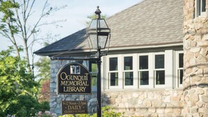 A stone building with a sign for the Ogounit Memorial Library, featuring a traditional lantern and a chain. - Cozy Nautical Getaway in Cape Neddick (Ogunquit)