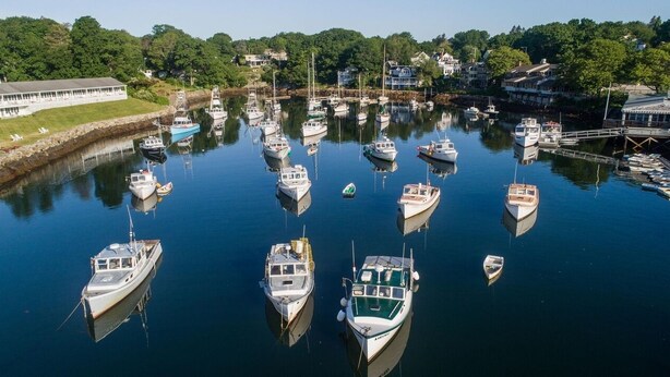 A marina with various boats docked, surrounded by residential buildings and greenery. - Cozy Nautical Getaway in Cape Neddick (Ogunquit)