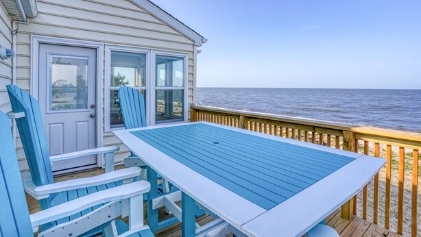 A deck with a table and chairs, overlooking the ocean. - Secluded Beach home with amazing views.  (Milford)
