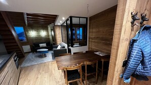 Un interior moderno con una mesa de comedor de madera, sillas, un sofá y una zona de cocina.