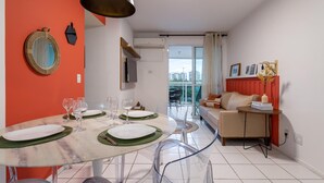 A modern living room with a dining area, a sofa, and a balcony with a city view. - Beauty at Recreio For 5 Peopple Sa201 (Rio de Janeiro)