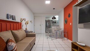 A modern living room with a sofa, a dining area with a table and chairs, and a kitchen in the background. - Beauty at Recreio For 5 Peopple Sa201 (Rio de Janeiro)
