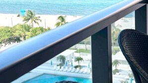 A balcony with a view of the ocean and a pool area. - Ocean Front Condo - Walk out to the Sand (Miami)