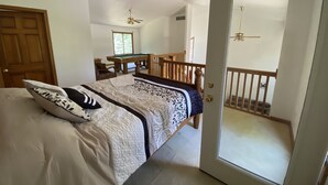 A bedroom with a bed, a pool table, a balcony with a railing, and a door leading to another room. - Riverside/Fishing/Arcade/Pool Table/Disk Golf/Fire Pit/Basketball/Pets/WiFi/UTV (Marion)