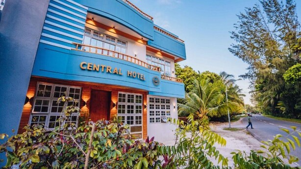 Een gebouw met twee verdiepingen, met het bord "CENTRAL HOTEL" op de gevel.