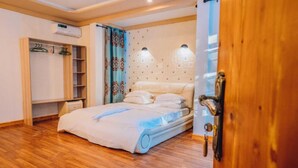 Een slaapkamer met een bed, een kledingkast en een airconditioning.