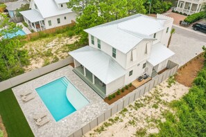A modern two-story house with a large swimming pool and outdoor seating area. - 30 A-mazing! Private Heated Pool, 4 bedroom, 6 Seater Golf Cart & Bikes! (Santa Rosa Beach)