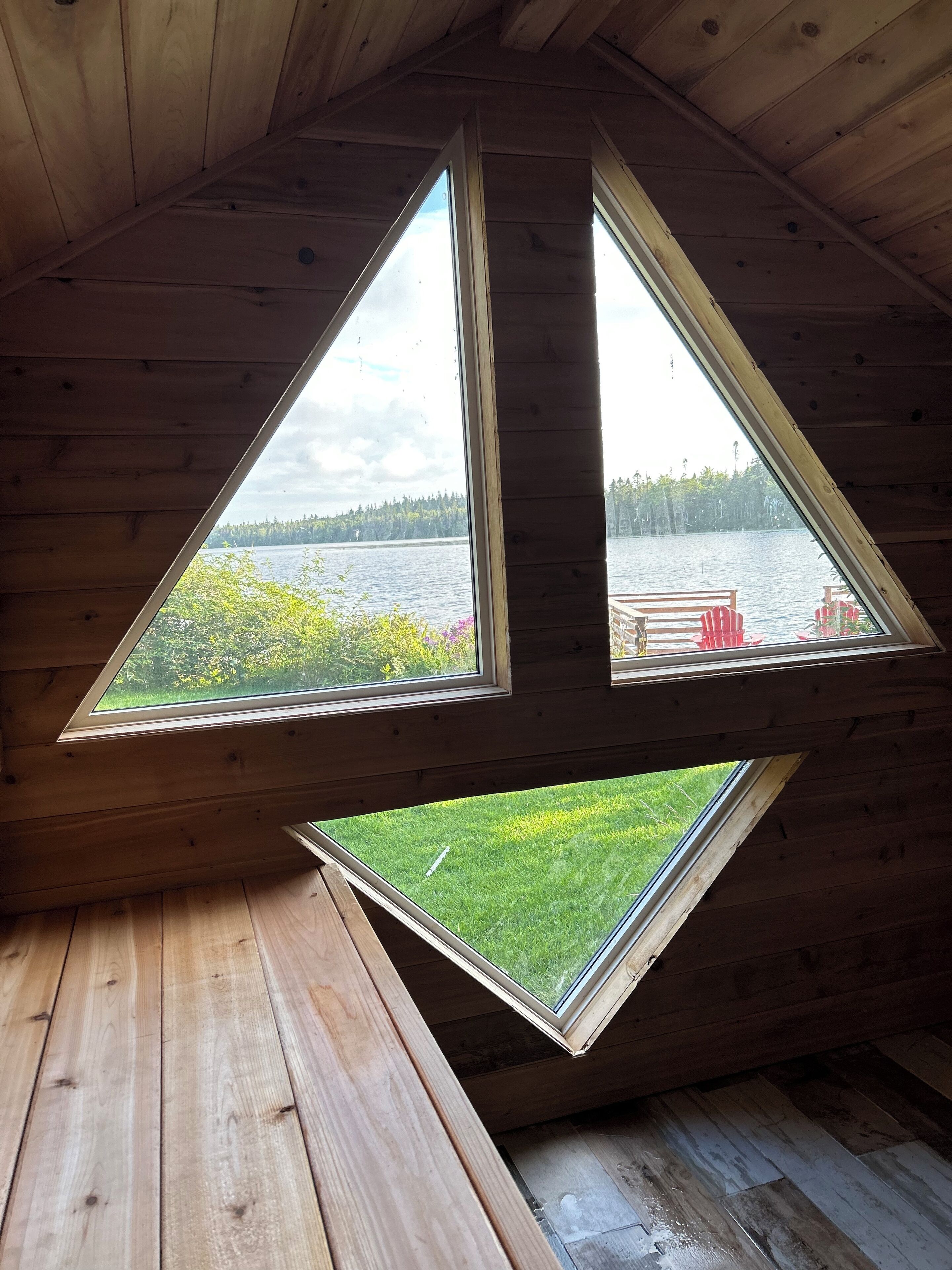 Une cabane avec un toit en pente et des fenêtres triangulaires.