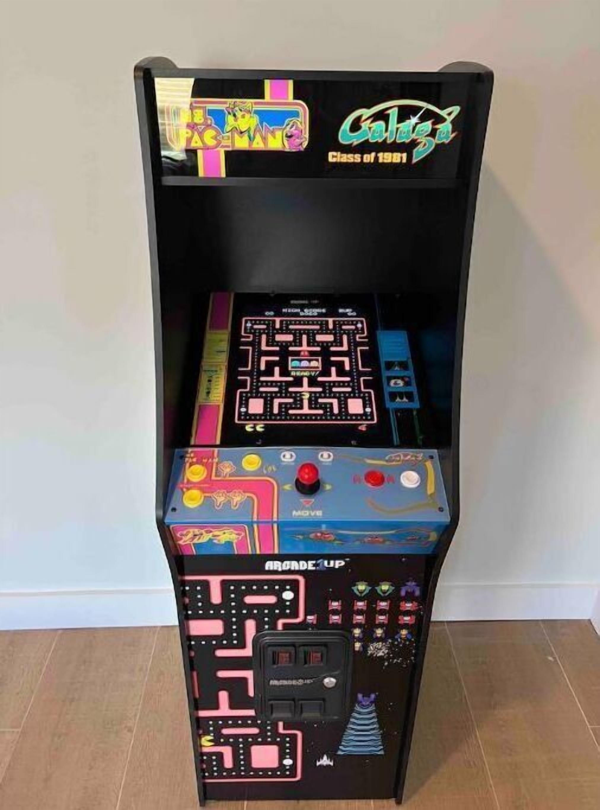 Una máquina de videojuegos retro con un juego de laberinto, un joystick y una ranura para monedas.