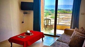 Leilighet – deluxe | Oppholdsområde | En 32-tommers TV med digitale kanaler samt peis