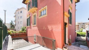 A red building with balconies and a paved area in front. - Country house, surrounded by greenery and nature. Great for relaxation (Camaiore)