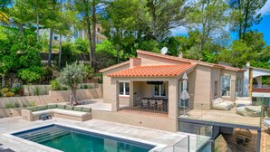 Una casa moderna con piscina, area salotto all'aperto e terrazza.