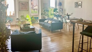 Ett rymligt vardagsrum med en soffa, ett soffbord och en matplats.