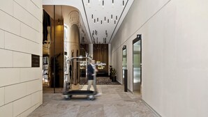 Un moderno vestíbulo de hotel con suelo de mármol, una recepción y un cartel que dice "your cityides journey starts here".