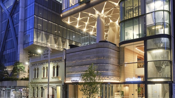 Un edificio moderno con fachada de vidrio, entrada visible y señalización con los rótulos 'citi' y 'E.W. Walker'.