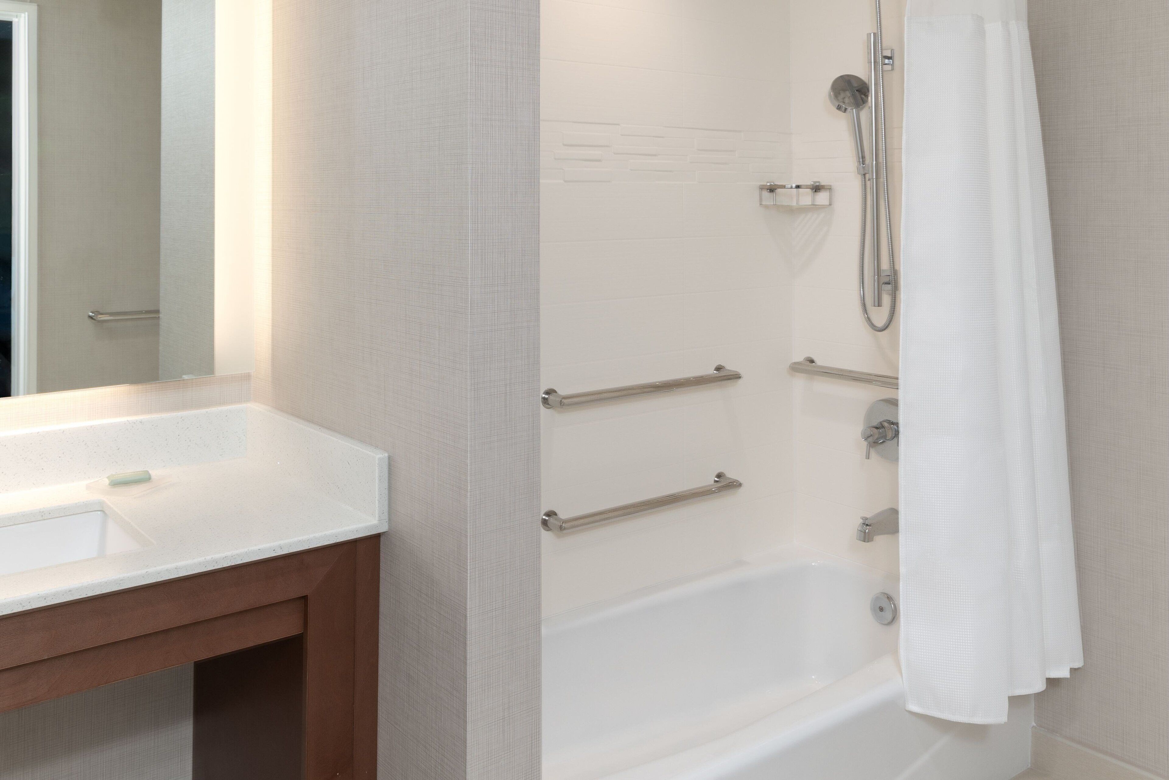 A bathroom with a white sink, a bathtub, and a shower with a curtain.