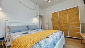 Une chambre à coucher avec un lit, une armoire en bois et une table de chevet.