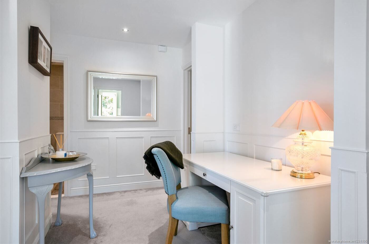 A small, neatly organized bedroom with a single bed, a bedside table, a chair, and a nightstand.
