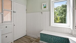 A room with a white wardrobe, a window with a view of trees, and a small picture on the wall. - Luxurious 2-Bed Apartment - Jun-Aug Weekly Rate (Rathfarnam Dublin 14)