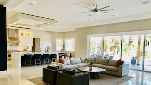 A modern living room with a large sofa, a coffee table, and a dining area with bar stools. - Resort Living Las Vegas (Las Vegas)