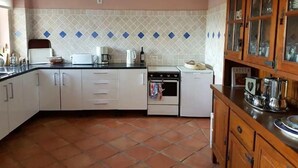 A kitchen with white cabinets, a stove, a microwave, and a coffee maker. - Spacious apartment in Historical Country Estate (Teulada)