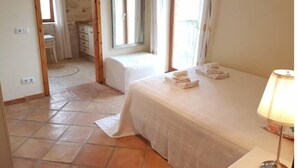A bedroom with a bed, a bedside table, a lamp, and a window. - Spacious apartment in Historical Country Estate (Teulada)