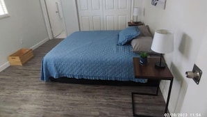 A bedroom with a bed, bedside table, lamp, and a small plant. - Convenient, cozy and bright  :)  (New Port Richey)