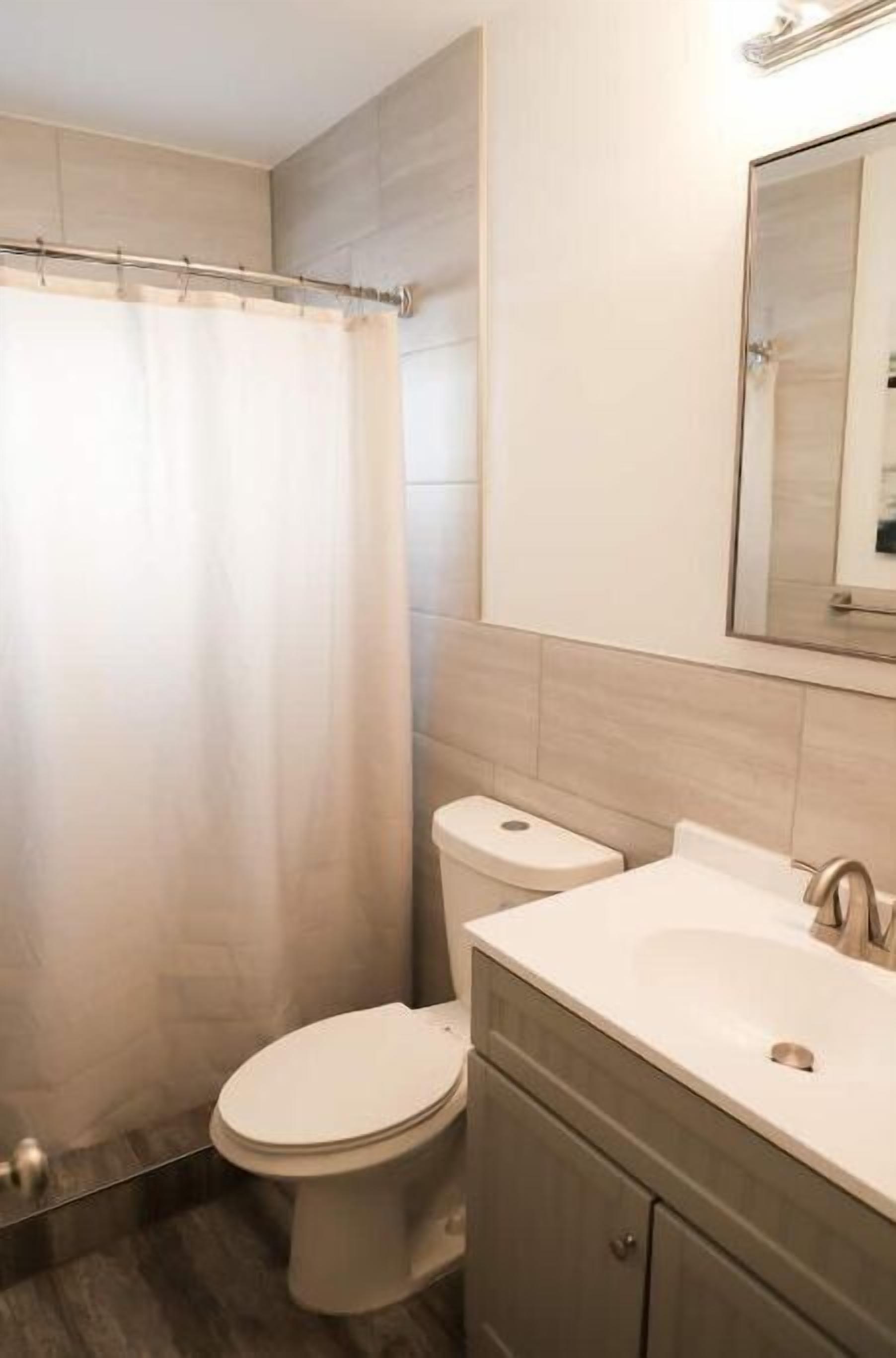 Une salle de bain avec des toilettes, un lavabo et un miroir.