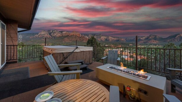 A balcony with a wooden table, chairs, and a grill. - Walk to Uptown with Breathtaking Views and HotTub! (Sedona)