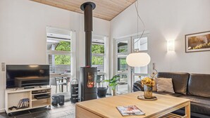Una sala de estar moderna con chimenea, un sofá, un televisor y un comedor.