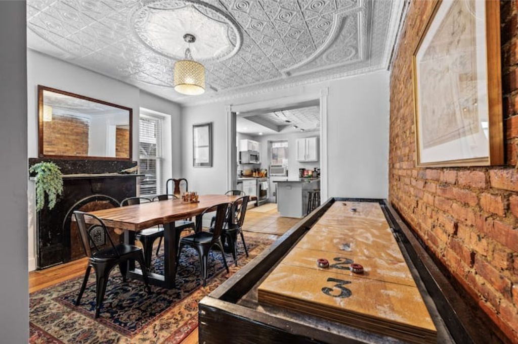 Een eetgedeelte met een houten tafel, zwarte stoelen en een tafel voor jeu de boules.