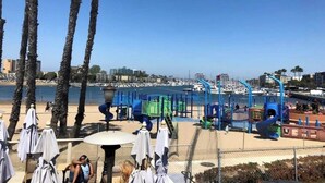 A beachside playground with palm trees and a view of the marina. - Marine Life: Smell the Sea, Feel the Breeze (Marina del Rey)