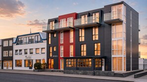 A multi-story hotel with a modern facade, large windows, and balconies. - ASKA Holt (Reykjavik)