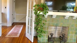 Una cocina con salpicadero de azulejos, chimenea y planta colgante.