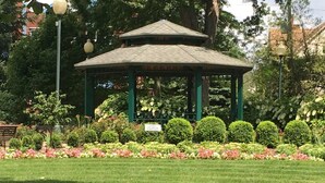 Una pérgola con techo verde y un letrero al frente.