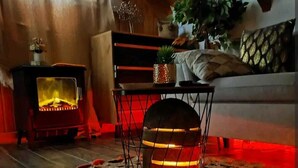Ein gemütliches Wohnzimmer mit Kamin, einem gemusterten Teppich und einer Couch.