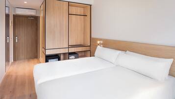 Un dormitorio moderno con una cama grande, armario de madera y espacio de almacenamiento integrado.