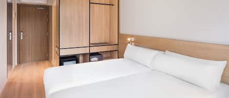 A modern bedroom with a large bed, wooden wardrobe, and built-in storage.