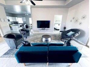 Relax in this stylish living room with a sofa, armchair, and flat-screen TV.