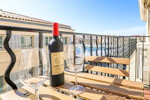 Enjoy a glass of wine on the balcony overlooking the marina, where boats and buildings meet the sea.
