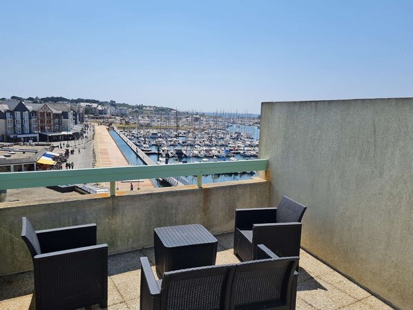 A balcony with wicker chairs overlooking a marina with numerous boats. - Appartement en Duplex Avec vue Port Crouesty Pour Cinq Personnes (ARZON)