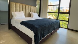 Ein modernes Schlafzimmer mit einem großen Bett und Blick auf die Stadt durch ein großes Fenster, wobei sich die Skyline draußen erstreckt.