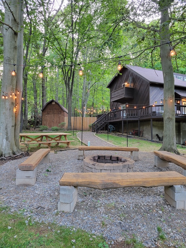 Ein rustikales Blockhaus mit Holzterrasse und Feuerstelle.