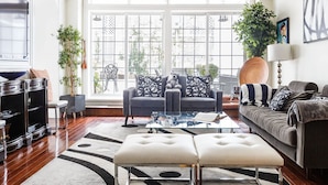 A spacious living room with a large window, a sofa, a coffee table, and a TV.