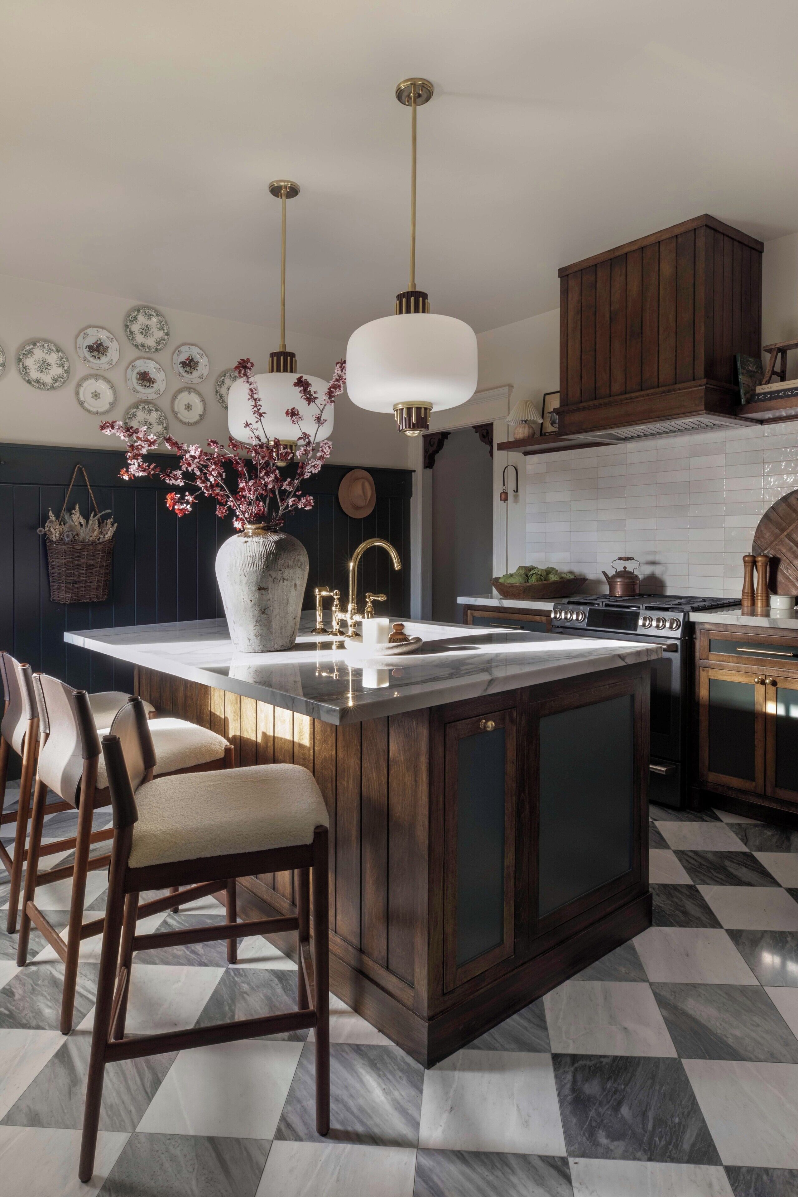 A kitchen with a central island, dark wooden cabinets, a checkered floor, and pendant lighting.