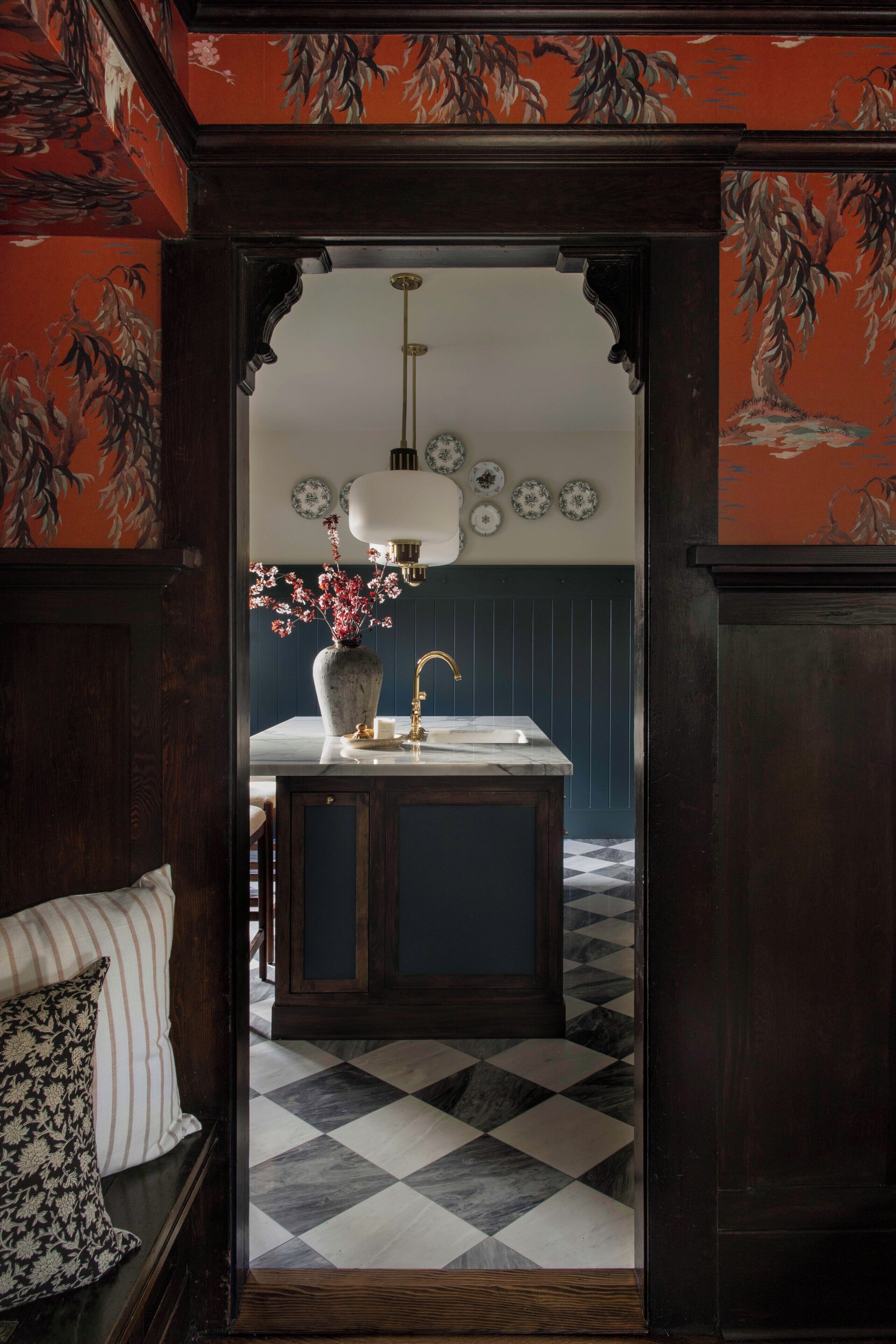 A kitchen with a marble countertop, a sink, and a vase with flowers.