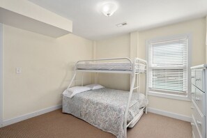 A bunk bed room with a window and a dresser. - Footloose & Fab-Semi-oceanfront, pool, hot tub, rec room, pool table, elevator! (Nags Head)