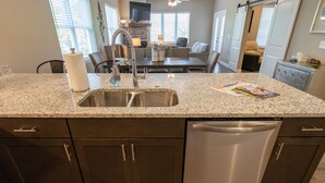 Una cocina con encimeras de granito, electrodomésticos de acero inoxidable y muebles oscuros.